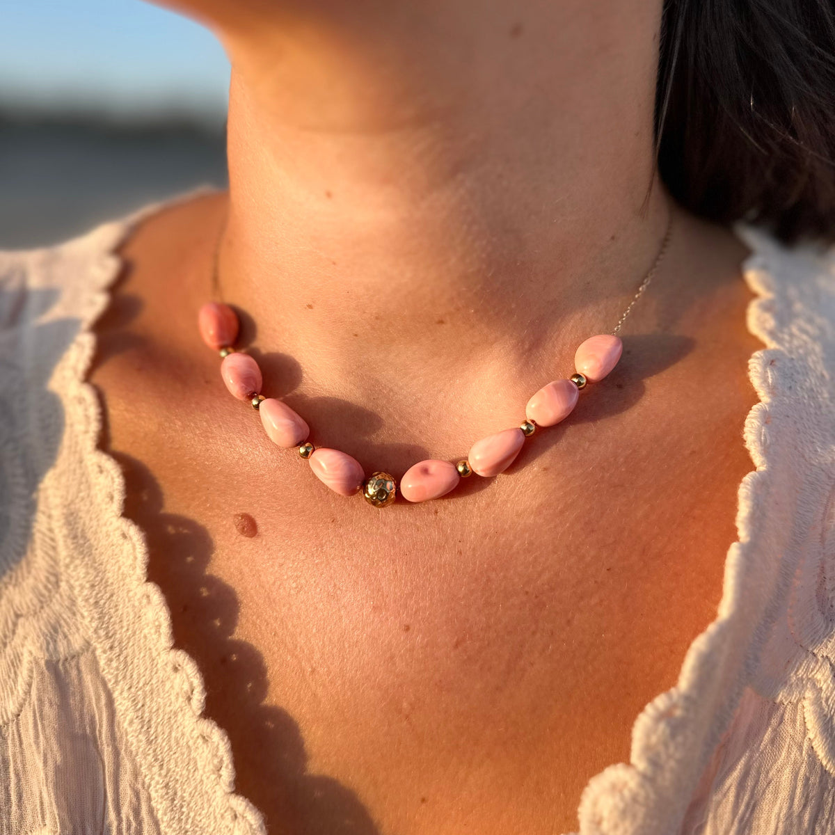 Collier fin avec perles en resine roses pastel, porte au cou