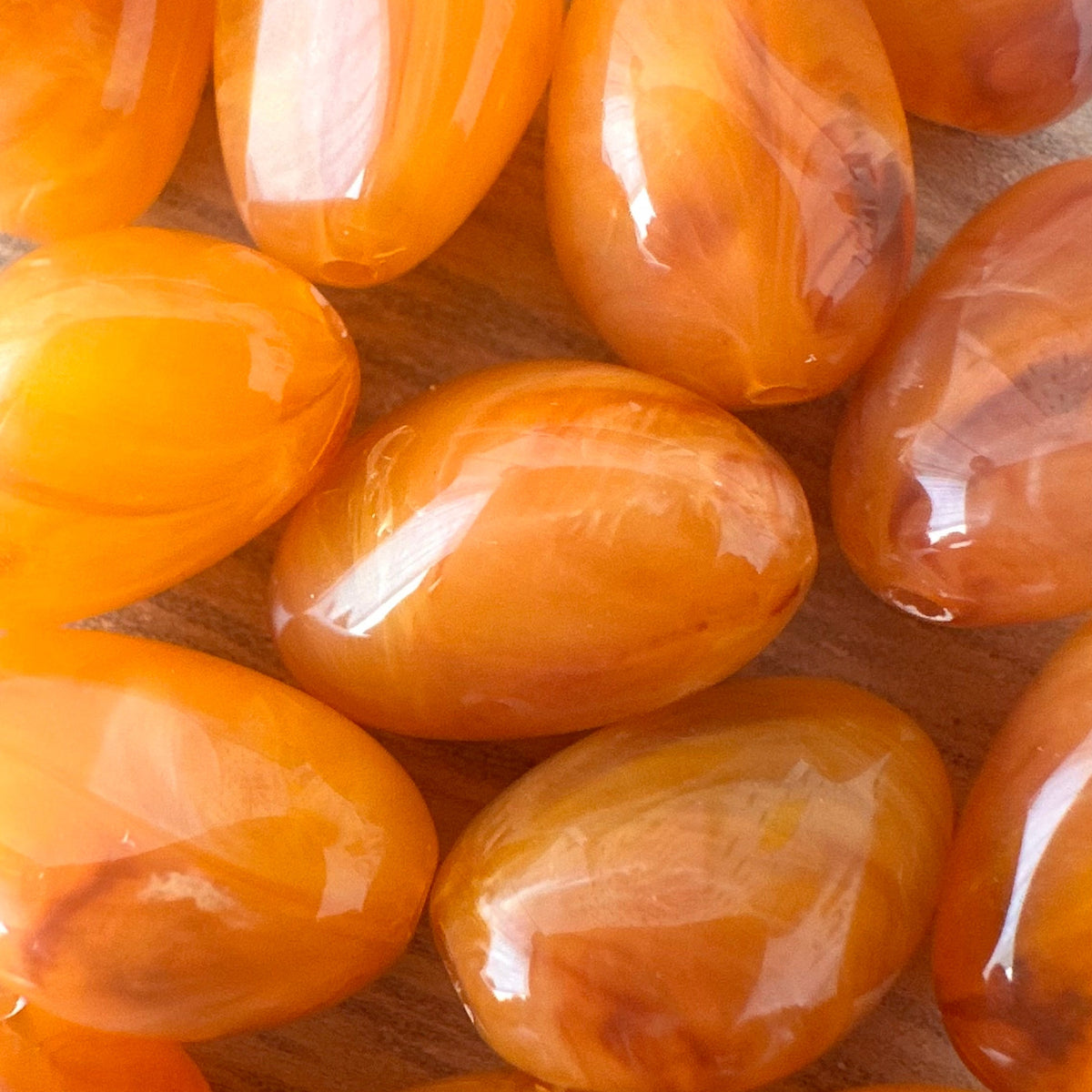 Gros plan sur la texture marbree des perles en resine orange